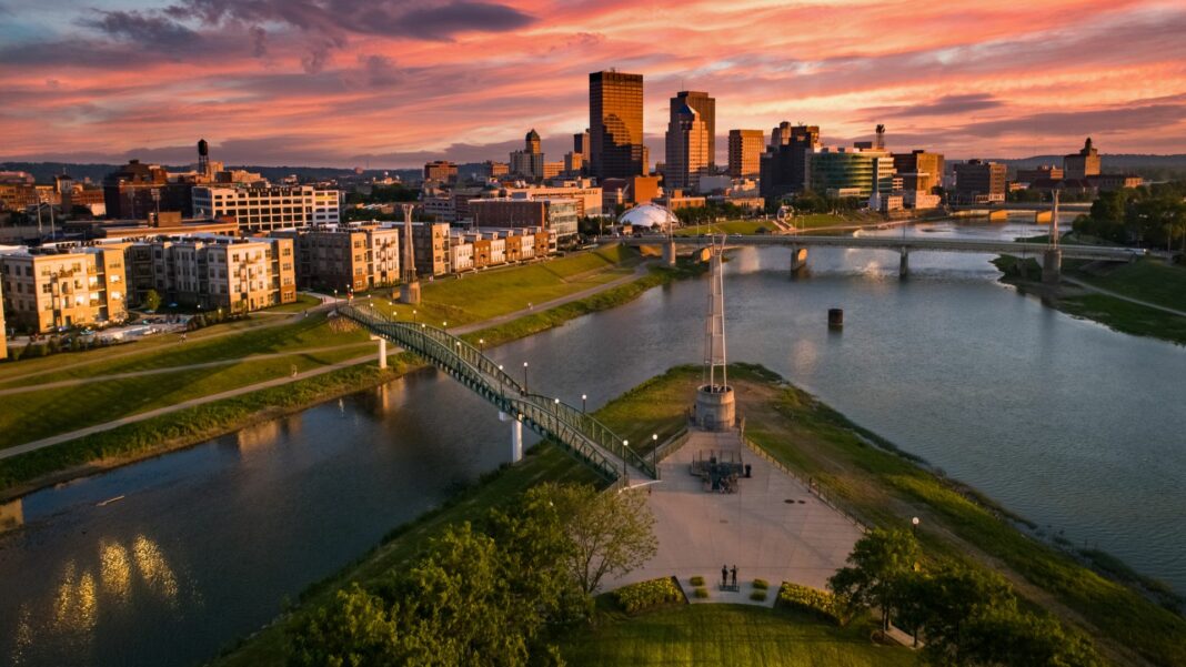 An aerial drone view over a park looking towards downtown Dayton, Ohio at sunset